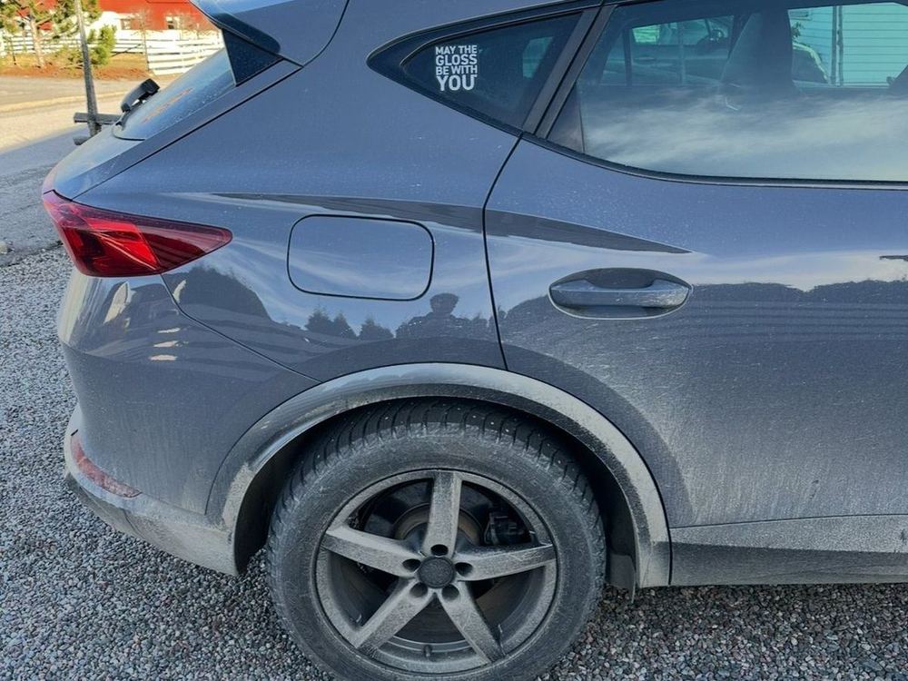 Smutsig bakskärm, fälg och däck på en grå SUV före utvändig rekond
