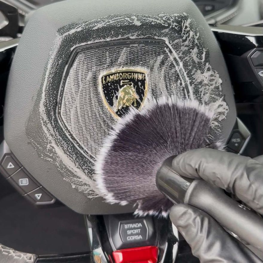 Ratten i en Lamborghini rengörs med mjuk pensel och skum vid invändig rekond
